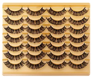 Macro detail of 20 pairs of dense curly black eyelashes arranged in a golden tray