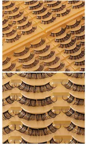 Macro shot of 14 pairs of D-curl segmented false eyelashes in a golden tray