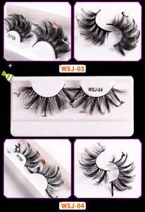 Macro detail of thick Halloween false eyelashes with small bat and pumpkin decorative patches