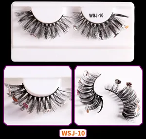 Detail of Halloween false eyelashes with pumpkin and ghost charms on fluffy mink fibers