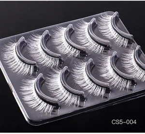 Detailed macro view of 7 pairs of thick white synthetic eyelashes on a black tray