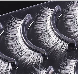 Detailed close-up of 5 pairs of white synthetic fiber eyelashes for stage makeup and parties