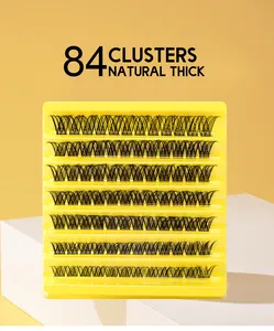 Detail of 84 natural thick lash clusters in yellow packaging on a white platform
