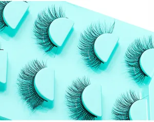 Vue macro de faux cils épais effet vison dans un plateau de présentation turquoise