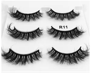 Detail of 3D fluffy 6D faux mink eyelashes in style R11 with 3 pairs on a white tray