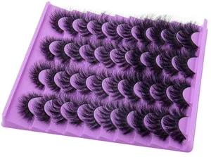 Detailed macro view of multiple pairs of thick black eyelashes in a purple display tray