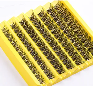 Close-up of 7 rows of natural segmented black cluster eyelashes in a yellow plastic tray