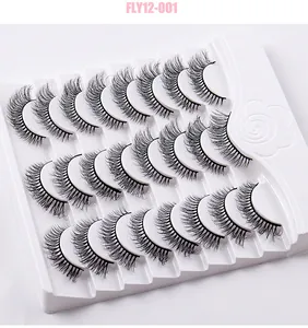 Macro view of 14 pairs of fluffy, criss-cross curly false eyelashes on a white tray