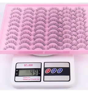 Macro shot of 35 pairs of false eyelashes in pink tray showing a weight of 49g on scale