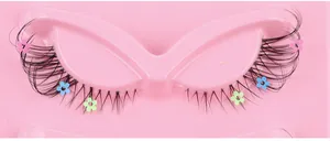 Close-up of black false eyelashes with colorful mini flowers on a pink tray
