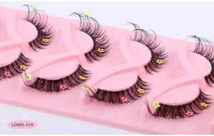 Detail showing 5 pairs of black false eyelashes with colorful flower sequins on a pink tray