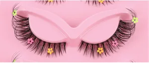 Close-up of false eyelashes with colorful flower sequins on a pink tray base