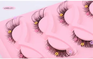 Detail of fox-style false eyelashes with colorful floral sequins on a pink tray