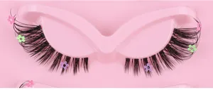 Detail of fox-style false eyelashes with tiny colorful floral sequins on pink tray