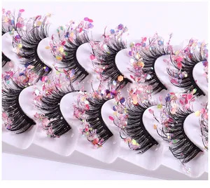 Makroaufnahme dichter falscher Wimpern mit rosa holografischen Pailletten für Party-Make-up