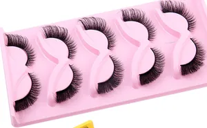 Detailed close-up of 5 pairs of voluminous wispy faux mink eyelashes on a pink tray