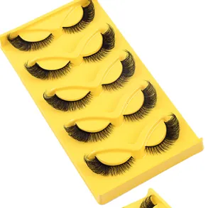 Detail view of 5 pairs of natural thick false eyelashes with extended eye ends in a tray