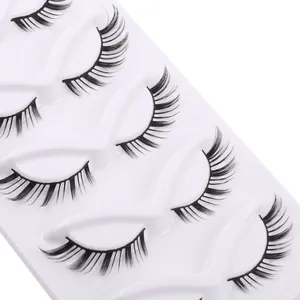 Five pairs of thick black false eyelashes with natural curl on white tray for makeup
