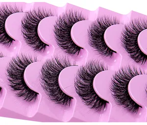 Gros plan de 8 paires de faux cils épais et bouclés sur un plateau en plastique rose