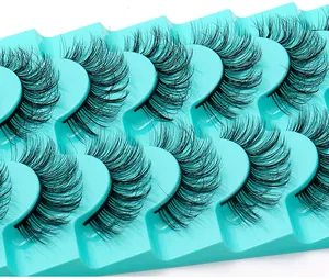 Gros plan de 8 paires de faux cils denses et recourbés sur des supports turquoise vifs