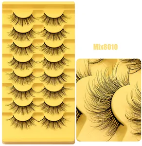 Détail macro de 8 paires de faux cils volumineux croisés sur des plateaux jaunes