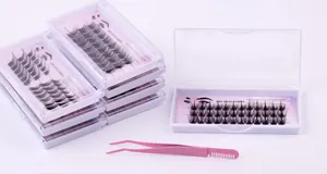 Macro view of DIY individual eyelash extension clusters with professional pink tweezers