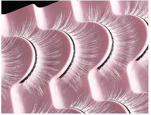 Makroansicht weißer Kunstfaser-Wimpern auf rosa gewelltem Tray für festliches Bühnen-Makeup