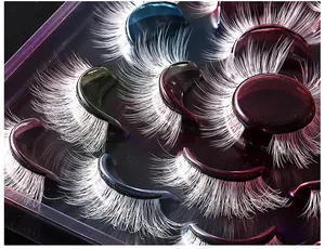 Detail of 10 pairs of white false eyelashes with metallic colorful bands for festival makeup