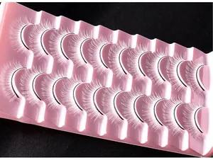 Makroaufnahme von 10 Paar weißen Theater-Wimpern auf einer rosa gewellten Halterung
