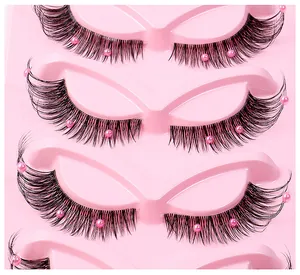 Detailed close-up of fox-eye false eyelashes with clear bands and pink pearl accents