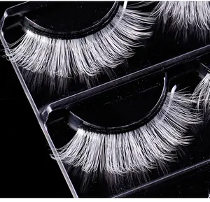 Macro view of white synthetic fiber eyelashes for stage makeup in a black display tray