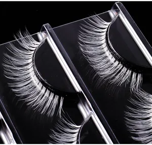 Macro detail of white synthetic fiber eyelashes for stage makeup on black background