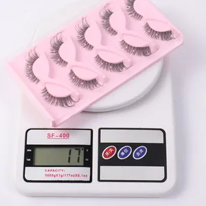 Detailed view of 5 pairs of false eyelashes with pink pearls weighing 17g on a scale