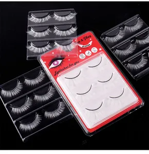 Macro shot of 3 pairs of white synthetic fiber eyelashes in red packaging for stage makeup