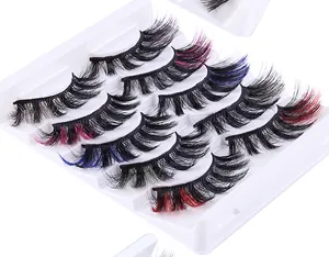 Detailed view of colorful faux mink eyelashes with red and blue feather accents in a tray
