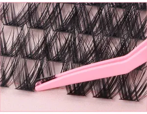Macro-opname van zwarte individuele wimperclusters die worden opgepakt met roze pincet