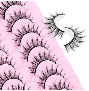 Makroansicht von 10 Paar gekreuzten künstlichen Wimpern im Barbie-Stil auf Rosa