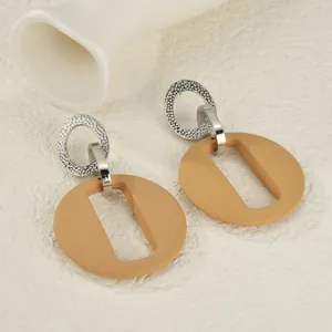 Détail de boucles d'oreilles géométriques argentées avec pendentifs en acrylique