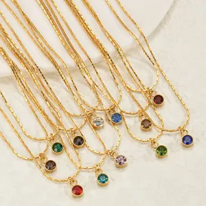 Détail de colliers en acier doré avec pendentifs de pierres de naissance colorées
