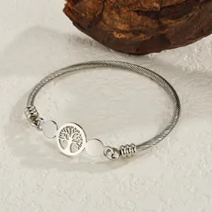 Silver twisted wire stainless steel bangle featuring a cutout Tree of Life charm