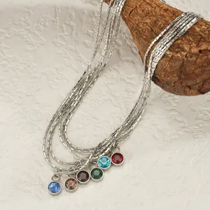 Détail d'un collier à plusieurs rangs en argent avec six pierres précieuses colorées sur bois