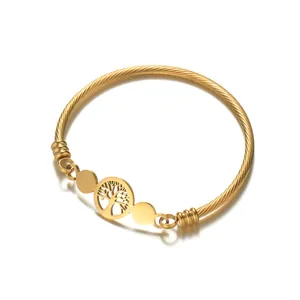 Gold twisted wire bracelet with a hollow Tree of Life charm and polished metal tags
