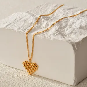 18K gold plated stainless steel necklace with textured heart pendant on white stone