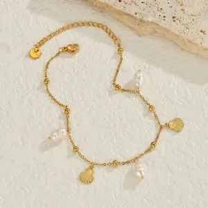Bracelet de cheville en acier inoxydable doré avec coquillage et perle sur fond pierre