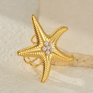 Elegante 18K vergulde zeester ring voor dames met witte parels op een getextureerde achtergrond