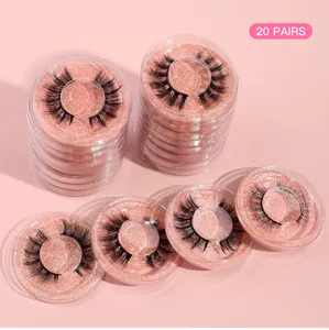 Detailed view of 20 pairs of dense black false eyelashes in pink glitter round boxes