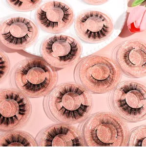 Macro detail of mixed dense false eyelashes set in pink glitter round boxes