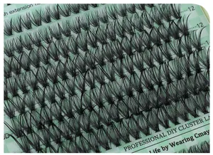 Macro detail of 12mm individual cluster lashes with 3D natural curl on green grid