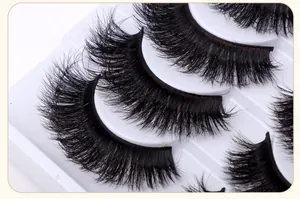 Macro detail of 10 pairs of dense criss-cross fluffy false eyelashes on a white tray