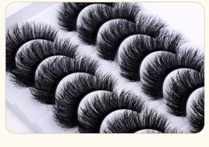 Macro detail of 7 pairs of thick crisscross false eyelashes on a white tray